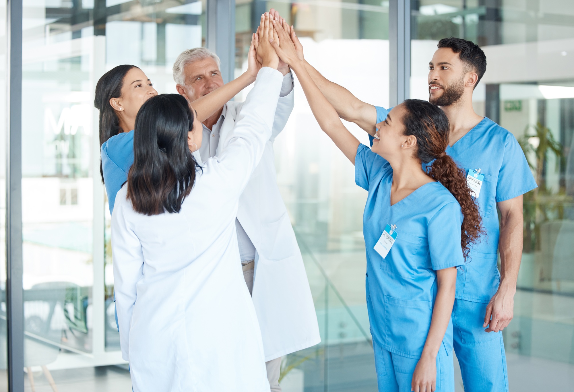 Shot of a team of medical staff high fiving one another